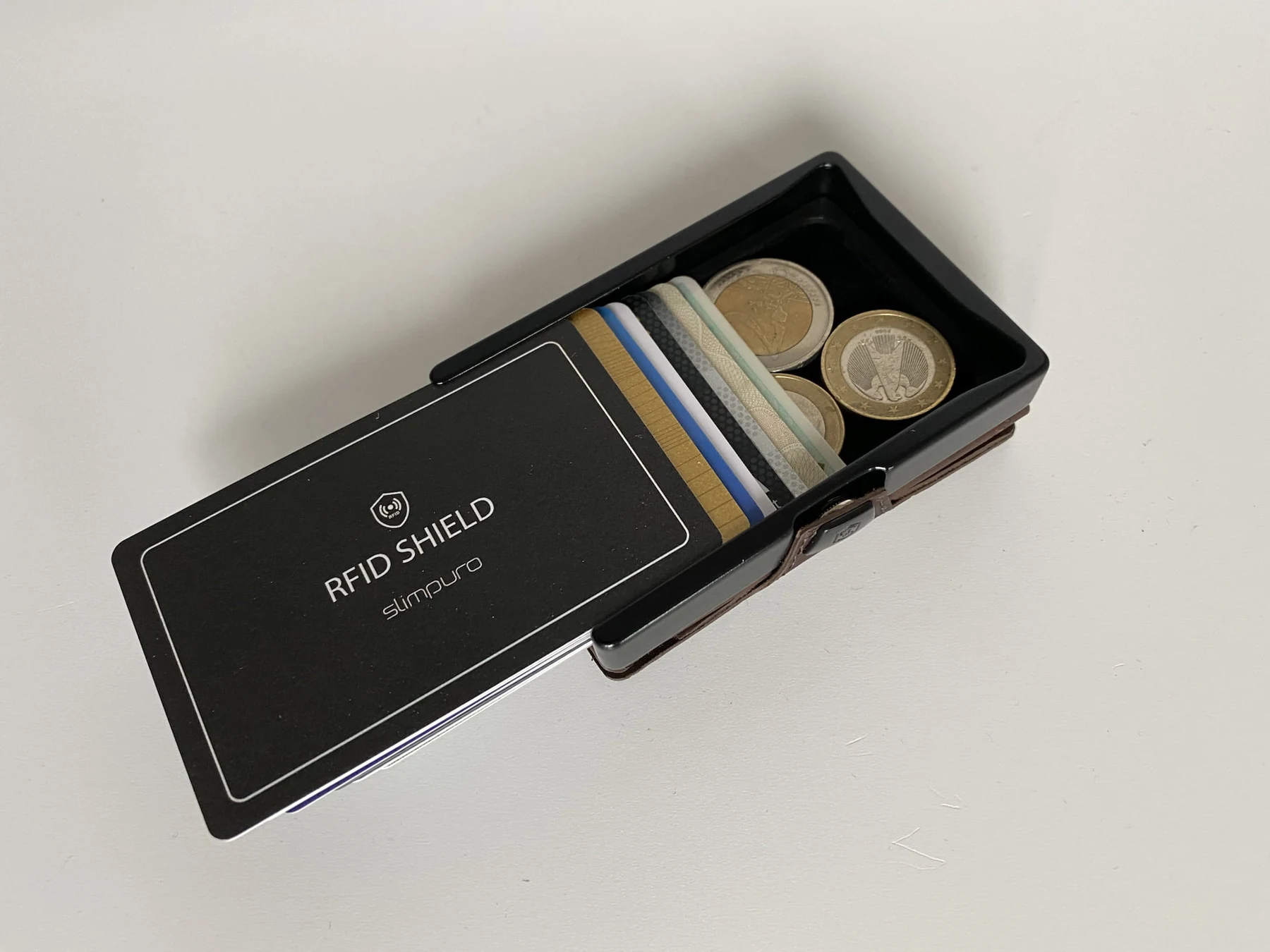 A ZNAP slim card holder with cards and its removable coin compartment visible.